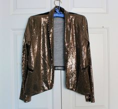 "Vintage Sequin Jacket, Handmade Fabric and Faux Leather Blazer Wear, Stretch Easy Wear, Not Lined, Styled 90s Wear, Simple Club Dinner Dress Up Vintage open-front dress jacket, handmade. With front and sleeves adorned in tiny sequins dark brown fabric while the back is made of black polyvinyl.  The jacket features shoulder pads and front falls pockets.  Please note that due to its vintage nature, there may be some missing sequins. There are no refunds or exchanges, items are sold \"as is\" or \"all sales are final\", but it is my goal to provide 100% customer satisfaction, so if you have any questions about an item, please contact me. In accordance with my terms of business, I have specified that there are no refunds due to shipping delays or loss the parcel.  With you agreeing to purchas Winter Going Out Fitted Blazer, Winter Outerwear With Sequins, Fitted Winter Outerwear For Going Out, Vintage Sequin Jacket, 90s Wear, Faux Leather Blazer, Sequin Jacket, Club Dress, Dress Jacket