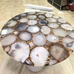 a glass table with rocks on it in the middle of a living room flooring