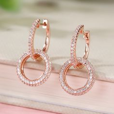 A striking twist on traditional hoop earrings, these beautifully designed dangles will add graceful movement and chic, contemporary style to any look. Highlighted by two interlocking, circle hoops, designed in high polished stering silver and glittering stones. For eye-catching movement and a dash of cool, contemporary style choose these chic dangle earrings.Carat Weight: 2.63 ctStone Size: 1,1.2 mmStone Type: Jeulia® StoneNumber of Stones: 248 Stone Shape: RoundStone Color: Diamond WhiteWeight: Elegant Single Open Circle Earring, Elegant Open Circle Hoop Earrings Gift, Modern Twist Single Round Earring, Modern Twist Round Earrings, Modern Round Earrings With Elegant Design, Elegant Open Circle Sterling Silver Earrings, Elegant Dangle Hoop Earrings With Halo Design, Elegant Rose Gold Circle Earrings, Modern Rose Gold Hoop Earrings For Wedding