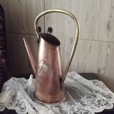 a metal watering can on a lace doily