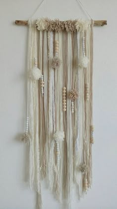 a white wall hanging with beads and tassels