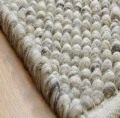 a close up view of a rug on the floor with wood floors in the background