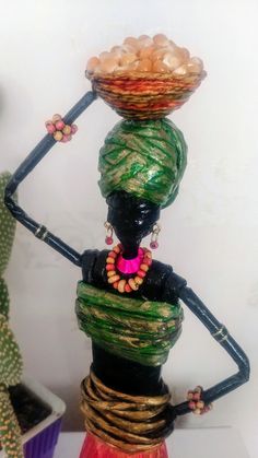 a statue made out of various items on top of each other, including a basket and beads