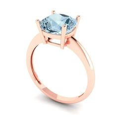 a rose gold engagement ring with an aqua blue topazte stone in the center