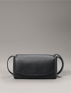 Crafted with a boxy silhouette, this crossbody bag is made with a structured, elevated design. Features a top flap with a snap button closure. Styled with an adjustable shoulder strap for a personalized fit.  Material: Sculpted Pu, 100% Pu. Modern Calvin Klein Business Bags, Calvin Klein Leather Shoulder Bag With Adjustable Strap, Minimalist Crossbody Shoulder Bag With Magnetic Closure, Calvin Klein Rectangular Bag With Adjustable Strap, Modern Calvin Klein Shoulder Bag For Business, Modern Calvin Klein Rectangular Shoulder Bag, Modern Satchel Flap Bag With Magnetic Closure, Modern Calvin Klein Leather Shoulder Bag, Classic Calvin Klein Satchel Shoulder Bag