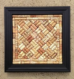 a framed cork art piece with wine corks in the center and black frame around it