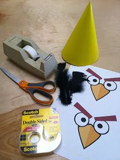 an angry bird cut out with construction paper and scissors on a table next to other crafting supplies