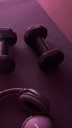 headphones and dumbbells on a purple mat