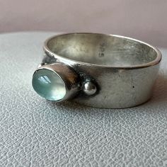 Beautiful Designer / Artisan Looking Wide Band Ring With A Pastel Aqua Blue Cabochon Glass Stone That Reminds Of An Aquamarine .Done In Solid 925 Sterling Silver ( Stamped And Tested ). Absolutely Gorgeous Color & Artisan Looking Ring! Cabochon Ring Design, Modern Silver Rings With Cabochon, Silver Turquoise Cabochon Ring, Aquamarine Cabochon Ring, Silversmith Rings, Artisan Silver Opal Cabochon Ring, Silver-setting Turquoise Cabochon Ring, Chunky Silver Rings, Cabochon Ring