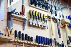 tools are hanging on the wall in a workshop