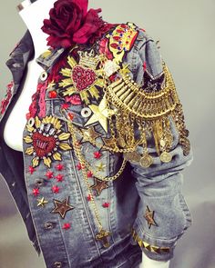 a mannequin wearing a denim jacket with gold and red decorations on the back