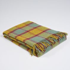 a green and yellow plaid blanket on a white background