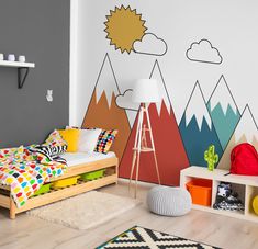 a child's bedroom with mountains painted on the wall