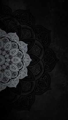 a black and white image of a flower on a dark background with an intricate design