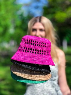 a woman in a white dress and pink hat is holding several hats on her shoulders