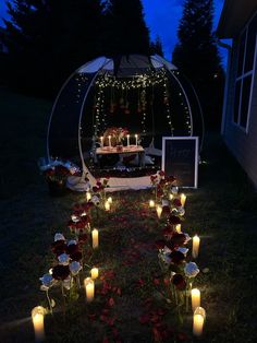 candles are lit in front of a gazebo decorated with flowers and lights at night