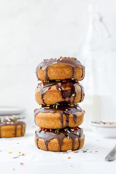 a stack of baked donuts with chocolate glaze and sprinkles