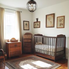 a baby's room with a crib, dressers and pictures on the wall