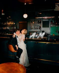 a bride and groom kissing at the bar