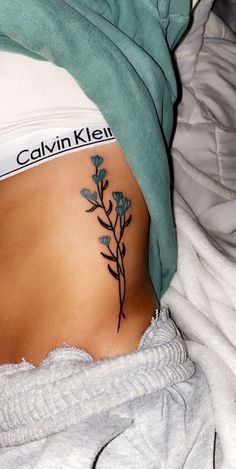 a woman's stomach with a small tattoo on her belly and the words, calvin klei above it