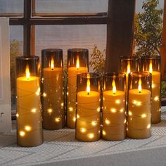 lit candles sitting on a table next to a window