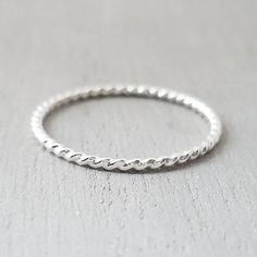 Silver twist ring. Made from .925 sterling silver Band measures 1.3mm thick. Handmade in NH, USA White Gold Twisted Modern Rings, Modern Twist Silver Stackable Rings, Minimalist Silver Twisted Ring, Minimalist Twisted Silver Ring, Silver Stackable Rings With A Modern Twist, Sterling Silver Twisted Rings With Modern Style, Silver Twisted Ring For Anniversary, Twisted Silver Rings For Anniversary, Modern Twisted Sterling Silver Rings