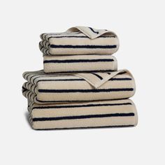 four towels stacked on top of each other in white and blue striped designs with black stripes