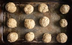 twelve uncooked doughnuts on a baking sheet ready to go into the oven