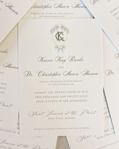 the wedding stationery is laid out on top of each other, with their monogrammed initials