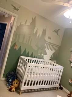 a baby's room with a white crib and green wallpapered walls