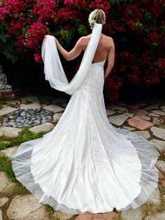 a woman in a wedding dress looking at flowers