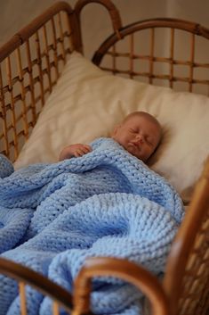 a baby wrapped up in a blue blanket