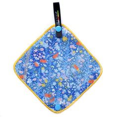 a blue and yellow flowered pot holder with a black clip on the top of it