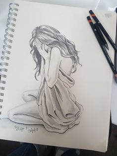 a pencil drawing of a woman sitting on the ground with her head in her hands