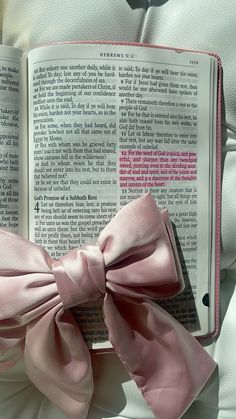 a pink bow on top of an open book