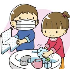 a boy and girl wearing face masks washing their hands at a table with toilet paper on it