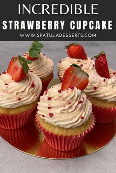 strawberry cupcakes with cream cheese frosting and strawberries on top, sitting on a red plate