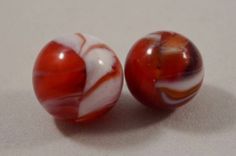 two red and white marbles sitting next to each other