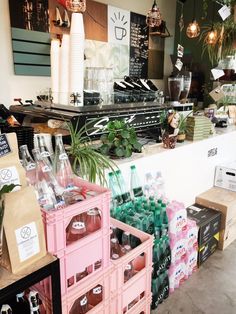 the inside of a coffee shop filled with lots of bottles and containers full of drinks