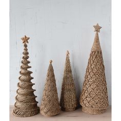 three small christmas trees are lined up on the table next to each other, one is made out of jute