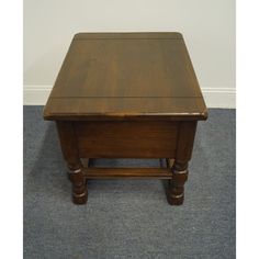 a small wooden table sitting on top of a carpeted floor