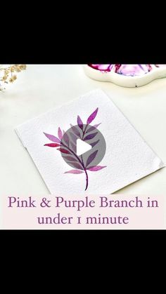 the pink and purple branch in under 1 minute is displayed on top of a white table