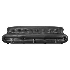 a black leather couch sitting on top of a white floor