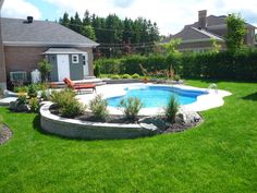 a backyard with a swimming pool surrounded by lush green grass