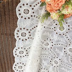 an orange flower is sitting on top of a white doily