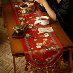 Crafted with the essence of 18th-century imperial Chinese porcelain, it is particularly revered for its official kiln red glaze. This table runner design embodies the grandeur of royal hues and intricate avian patterns, painting a vivid picture of spring's abundance. As you gaze through the window, be enchanted by a magnificent panorama of flourishing gardens and auspicious birds. The eight-sided jacquard patterns symbolize boundless prosperity in the new year, framing the scene within the window and enveloping you in the vibrant spirit of spring. Chinese New Year Table Decorations, Chinese New Year Table Setting, Patterns Painting, Bird Table, Embroidery Scarf, New Year Table, Wedding Scarf, Red Glaze, Chinese Embroidery