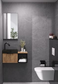 a bathroom with a toilet, sink and mirror in it's corner area on the wall