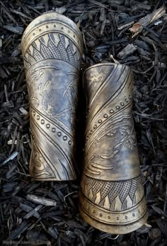 two old boots sitting on top of some mulch next to each other in the grass