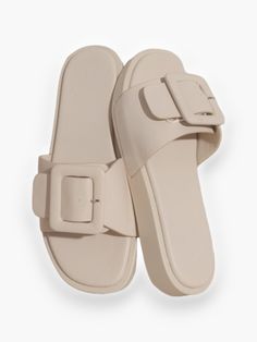 Step into style with the Bralyn Single Buckle Slide Sandal – a true showstopper that effortlessly elevates any outfit. Boasting a unique square-toe design and a striking single buckle detail, these slides are more than just footwear; they're a bold fashion statement. With a modest heel height of 0.75" and available in beige, white, or nude, the Bralyn slide adds a touch of individuality and flair to your look, making it a must-have for those who want to stand out with confidence. Features: Uniqu