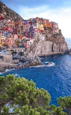 the colorful village is perched on top of a cliff by the water's edge